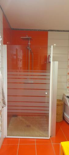 a shower in a bathroom with a red wall at Villa Sand 5mn château goutelas in Marcoux