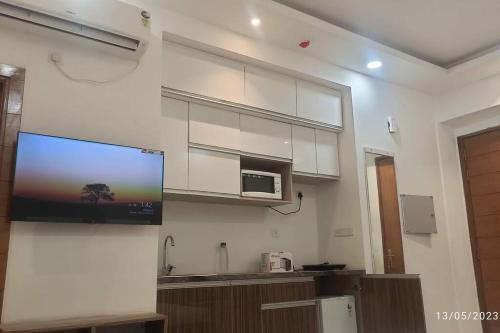 ein Flachbildfernseher an der Wand einer Küche in der Unterkunft Darshana Studios -Feel the luxury fully furnished in Noida
