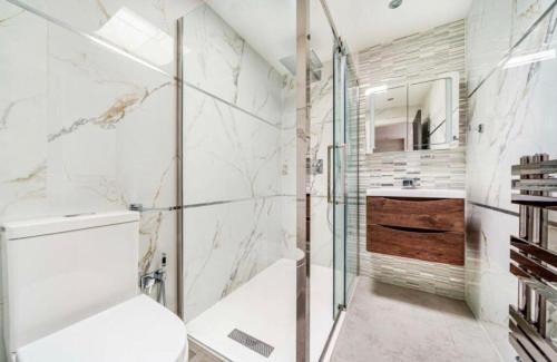 a bathroom with a shower and a toilet and a sink at Modern Family Home in Greater London in Pinner