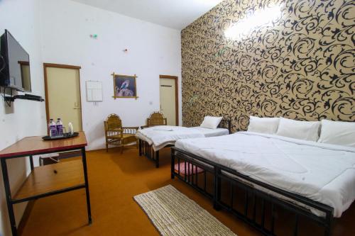 Habitación de hotel con 2 camas y TV en Saalwood Safari Lodge, en Dhanwār