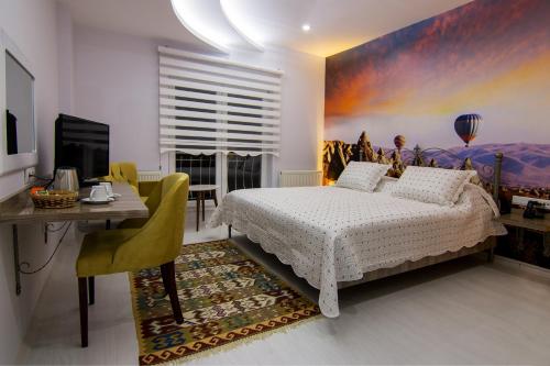 a bedroom with a bed and a table and a desk at Cappadocia Symbol Hotel in Uçhisar