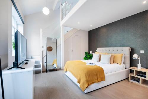 a bedroom with a white bed and a television at ARCORE Premium Apartments Bloomsbury in London