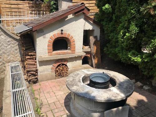 an outdoor grill with a pizza oven in a backyard at Omega Vendégház in Miskolc