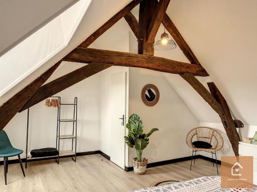 a attic room with wooden beams and a ladder at Bienvenue chez Noémie - Arrivée Autonome in Châtellerault