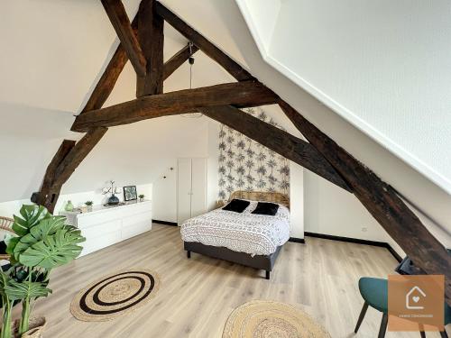 1 dormitorio con 1 cama en el ático en Bienvenue chez Noémie - Arrivée Autonome, en Châtellerault