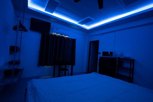 a room with a bed and a blue light at Splash Bar and Guesthouse in Pattaya Central