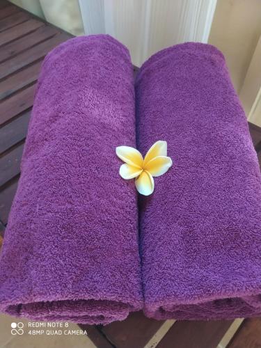 a purple towel with a flower on top of it at ASHVATTHA VILLA Canggu in Canggu