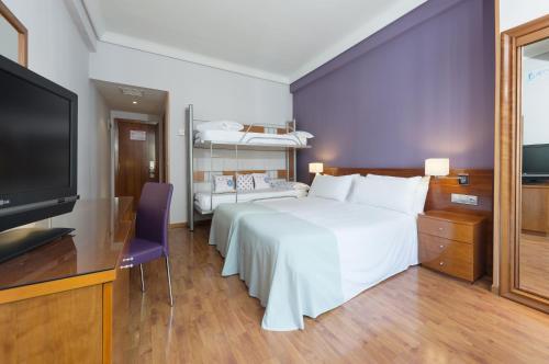 - une chambre avec un grand lit blanc et une télévision à écran plat dans l'établissement Hotel Madrid Centro, Affiliated by Meliá, à Madrid