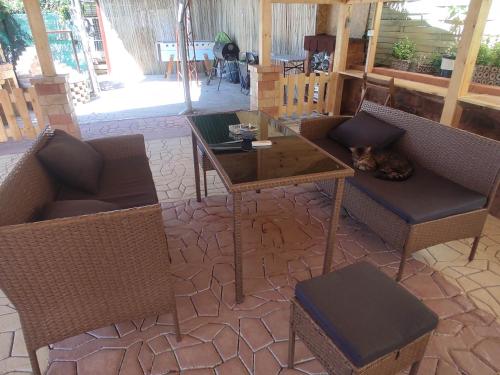 a patio with a table and chairs and a cat sleeping at Guesthouse Ilona in Veľký Kamenec