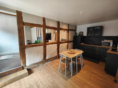 ein Wohnzimmer mit einem Tisch und einer Küche in der Unterkunft Bienvenus au Nid du Traminer in Eguisheim