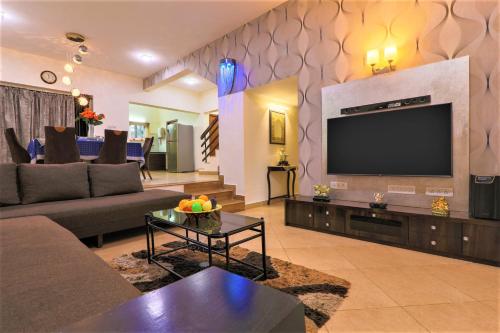 a living room with a flat screen tv on a wall at La Goa Villa - 4BHK Baga JAQK Holidays in Baga