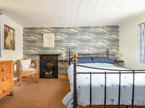 a bedroom with a bed and a fireplace at Swallow Cottage in Llandwrog