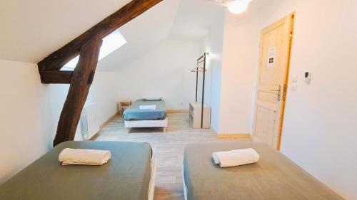 two beds in a room with a attic at Gite étape pour amoureux du vélo Azay centre 12p. in Azay-le-Rideau