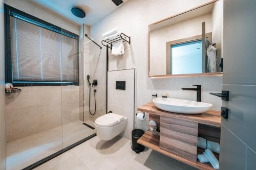 uma casa de banho com um lavatório, um WC e um chuveiro em KHAI HOTEL BODRUM em Bodrum City