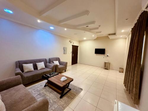 a living room with a couch and a tv at فلورز سويتس in Yanbu