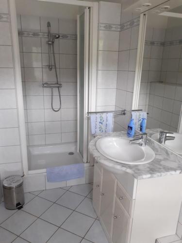 y baño blanco con lavabo y bañera. en LES VIGNERONS en Niedermorschwihr