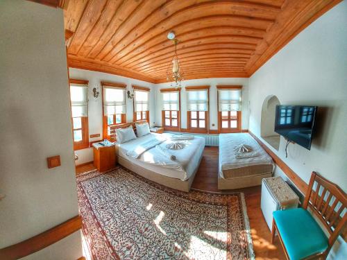 um quarto grande com uma cama grande e uma televisão de ecrã plano em Muhsin Bey Konağı em Saframbolu
