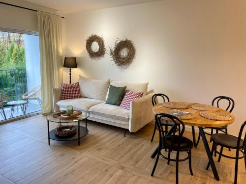 ein Wohnzimmer mit einem Sofa und einem Tisch in der Unterkunft Apartament FOREST - HOME APART in Ostróda