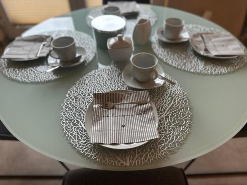 a white table with plates and cups and saucers at Palais -MehrGehtNicht-Maisonette in Großweitzschen