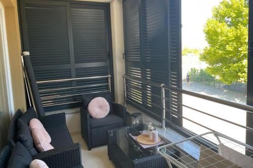 a balcony with chairs and a table and a window at New modern accommodation in city in Metković