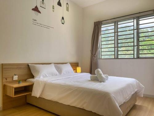 een slaapkamer met een groot wit bed en een raam bij Sunset view Homestay near Lake Garden w/ Swimming pool in Taiping