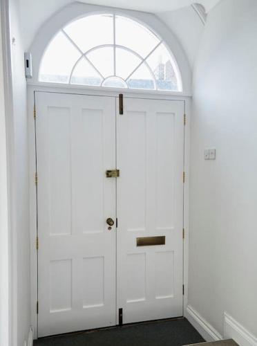 a white door in a room with an arched window at 3 bedroom converted chapel in historic Oundle in Oundle