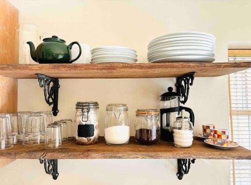 a shelf with dishes and jars and plates on it at 3 bedroom converted chapel in historic Oundle in Oundle