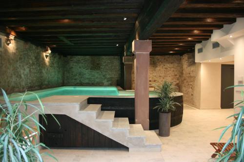 une piscine intérieure avec un escalier menant à une piscine dans l'établissement La Cour du Bailli Suites & Spa, à Bergheim