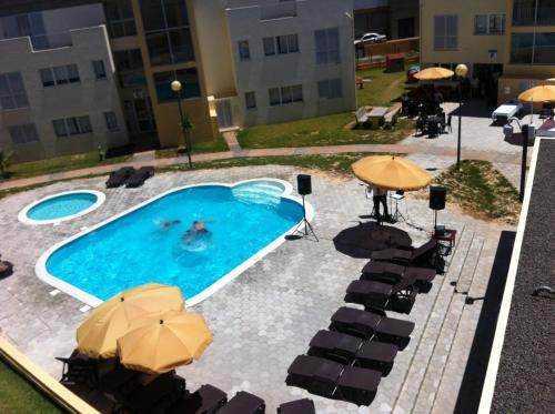 a swimming pool with umbrellas and tables and chairs at Paraiso Dourado in Porto Santo