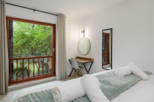 een slaapkamer met een bed, een raam en een bureau bij San Lameer Villa 1933 - 2 Bedroom Classic - 4 pax - San Lameer Rental Agency in Southbroom