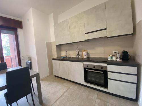 a kitchen with white cabinets and a stove top oven at Appartamento La finestra sul Parco in Dalmine