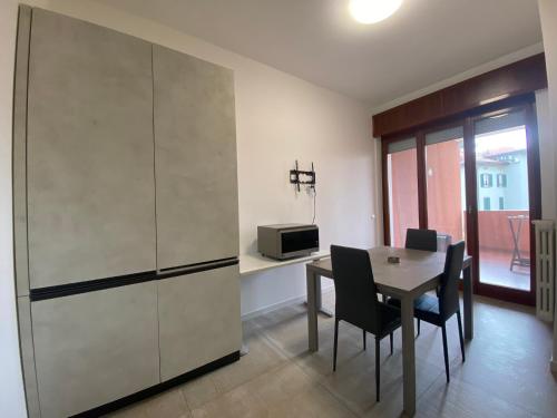 a dining room with a table and a refrigerator at Appartamento La finestra sul Parco in Dalmine