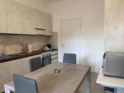 a kitchen with a table and some chairs in it at Appartamento La finestra sul Parco in Dalmine