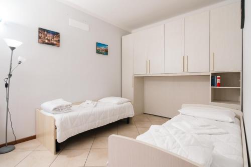 2 camas en una habitación con armarios blancos en Appartamento Scaligero en Verona