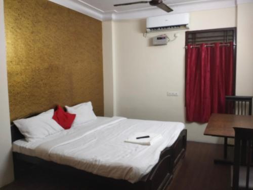 a bedroom with a bed with a red curtain at Hotel Sharma Residency Chennai Egmore in Chennai