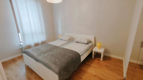 niewielka sypialnia z łóżkiem i stołem w obiekcie FIRST -- Green Żoliborz Apartment 4 w Warszawie