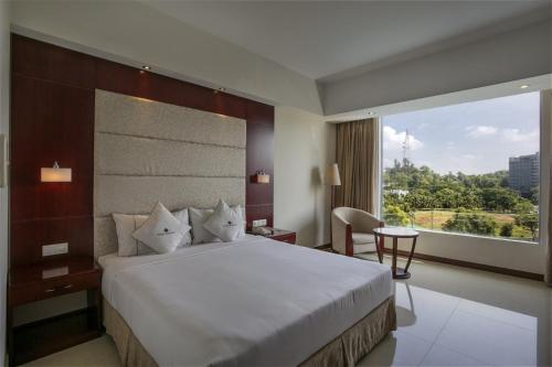 1 dormitorio con cama grande y ventana grande en Ocean Paradise Hotel and Resort, en Cox's Bazar