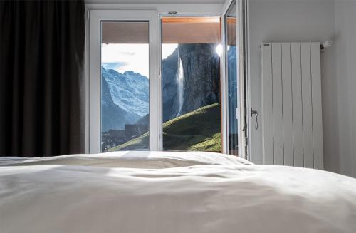 a bedroom with a bed and a view of a mountain at Hotel Silberhorn in Lauterbrunnen