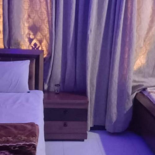 een slaapkamer met een bed en een paars gordijn bij Bodla Royal Hotel in Multan