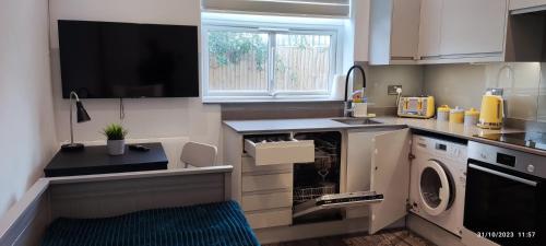 a kitchen with a washing machine and a window at Studio Flat / London Gateway in Borehamwood