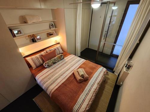 um pequeno quarto com uma cama com duas almofadas em Boutique City Apartment with Iconic Mountain Views em Camberra