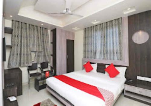 um quarto com uma cama grande e almofadas vermelhas em Hotel Anand International Bihar em Samastīpur