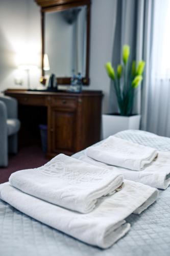 two beds with white towels on them in a hotel room at Hotel Villa Riviera in Rzeszów