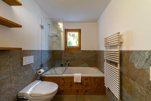 La salle de bains est pourvue d'une baignoire, de toilettes et d'un lavabo. dans l'établissement Chesa Diala - Zuoz, à Zuoz