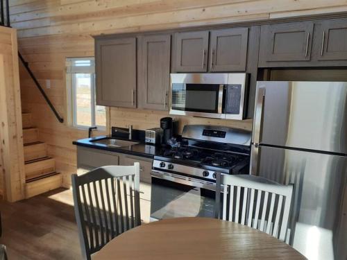 uma cozinha com um fogão, um frigorífico e uma mesa em 065 Star Gazing Tiny Home nr Grand Canyon South Rim Sleeps 8 em Valle