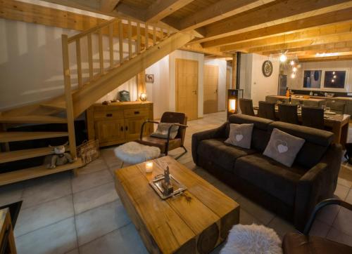 uma sala de estar com um sofá e uma mesa em Chalet proche des pistes de ski avec vue et spa em Gérardmer