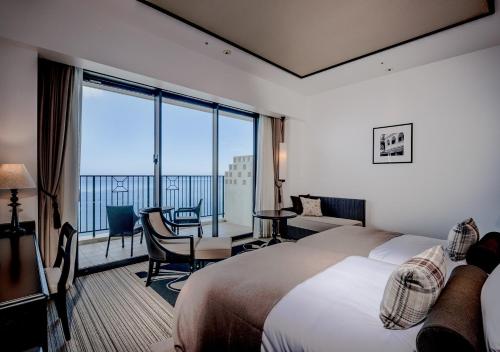 a hotel room with a bed and a large window at Hotel Monterey Okinawa Spa & Resort in Onna
