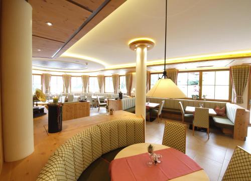 ein Restaurant mit Tischen und Stühlen in einem Zimmer in der Unterkunft Berghotel Alpenklang in Großarl