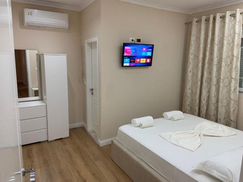 a bedroom with a bed with a tv on the wall at Vila Qyteza in Korçë
