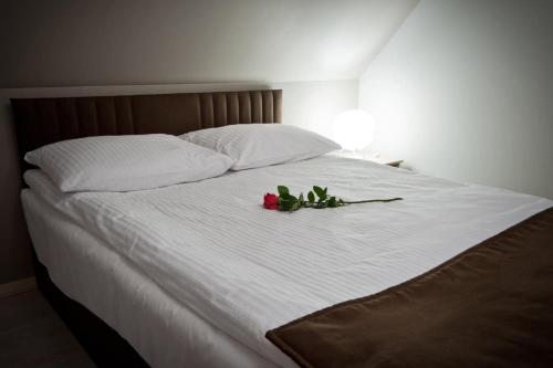 a white bed with a flower bouquet on it at BIESZCZADZKI RAJ Komfortowe domy z kominkami i Sauną na obiekcie in Olchowiec